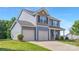 Light blue home featuring a two-car garage, well-manicured lawn, and classic architectural details at 129 Canada Dr # 85, Statesville, NC 28166