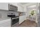 Modern kitchen showcases stainless steel oven and microwave, complemented by granite countertops and white cabinets at 129 Canada Dr # 85, Statesville, NC 28166
