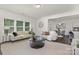 Open-concept living room featuring neutral tones, large windows, and seamless flow to the dining and kitchen area at 129 Canada Dr # 85, Statesville, NC 28166