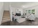Sunlit living room with plush seating, stylish decor, and a staircase that leads to the second story at 129 Canada Dr # 85, Statesville, NC 28166