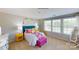 Bright bedroom with yellow nightstands and a colorful comforter by a window, butterfly wall art at 133 Way Cross Ln, Troutman, NC 28166
