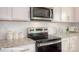 Close-up of a modern kitchen with stainless steel appliances and white cabinets at 136 Mary Locke Way, Statesville, NC 28677