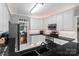 Open-concept kitchen with white cabinets, dark countertops, and stainless steel appliances at 1498 Farrow Dr, Rock Hill, SC 29732