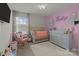 Charming Bedroom with soft pastel colors, a crib, and a comfortable rocking chair at 15021 Meacham Farm Dr, Huntersville, NC 28078