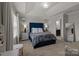 Comfortable bedroom with tufted headboard, neutral walls and ensuite bathroom at 15021 Meacham Farm Dr, Huntersville, NC 28078