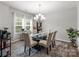 Beautiful dining room features a glass table, bright window and chandelier at 15021 Meacham Farm Dr, Huntersville, NC 28078
