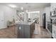 Modern kitchen featuring a gray island with pendant lighting, stainless steel appliances, and view into the adjacent dining room at 15021 Meacham Farm Dr, Huntersville, NC 28078