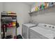 Functional laundry room equipped with a washer, dryer, and storage shelves at 15021 Meacham Farm Dr, Huntersville, NC 28078