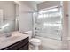 Bathroom with a white toilet, a shower and bath combo with glass doors, and a white sink at 15429 Topanga Dr, Charlotte, NC 28278