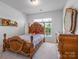 This bedroom features wood furniture, carpet, and a large window providing lots of natural light at 15429 Topanga Dr, Charlotte, NC 28278