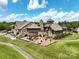 Elegant clubhouse featuring a stone facade, outdoor patio with pergola, and beautifully landscaped grounds at 15429 Topanga Dr, Charlotte, NC 28278