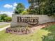 Stone community sign with landscaped flowerbed in front and manicured green grass at 15429 Topanga Dr, Charlotte, NC 28278