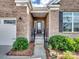 Inviting brick home entrance with landscaped bushes, white trim, and a charming front porch for a welcoming feel at 15429 Topanga Dr, Charlotte, NC 28278