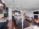 Gourmet kitchen with granite countertops, dark cabinetry, stainless steel appliances, and an island with seating at 15429 Topanga Dr, Charlotte, NC 28278
