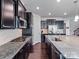 Well-equipped kitchen boasts dark cabinets, stainless steel appliances, granite countertops, and a functional layout at 15429 Topanga Dr, Charlotte, NC 28278