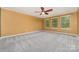 Spacious bedroom with neutral walls, plush gray carpet, and natural light from three windows at 15536 Oleander Dr # L228, Charlotte, NC 28278