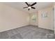 This bedroom features plush gray carpeting, a ceiling fan, and ample natural light through windows at 15536 Oleander Dr # L228, Charlotte, NC 28278
