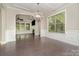 Dining room with hardwood floors, a modern light fixture, and an expansive view into the living room at 15536 Oleander Dr # L228, Charlotte, NC 28278