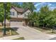 A two-story home with a two-car garage, landscaped front yard, and a long concrete driveway in a suburban neighborhood at 15536 Oleander Dr # L228, Charlotte, NC 28278