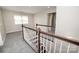 This hallway features plush gray carpets and wooden rails, leading to the main areas of the home at 15536 Oleander Dr # L228, Charlotte, NC 28278