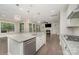 Open concept living space showcasing modern kitchen with white cabinets, stainless steel appliances, and seamless access to the living room at 15536 Oleander Dr # L228, Charlotte, NC 28278