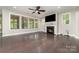 Spacious living room with hardwood floors, a ceiling fan, a fireplace, and three large windows overlooking the yard at 15536 Oleander Dr # L228, Charlotte, NC 28278