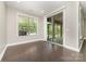 Bright room with hardwood floors, white trim, a large window with blinds, and a sliding glass door to an outdoor space at 15536 Oleander Dr # L228, Charlotte, NC 28278