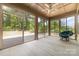 Relaxing sunroom with panoramic views of the landscaped yard, ceiling fan and comfortable seating at 15536 Oleander Dr # L228, Charlotte, NC 28278