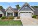 Charming home featuring a two-car garage, manicured lawn, and stylish architectural details under a bright blue sky at 1747 Slippery Rock Ln, Monroe, NC 28112