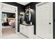 Stylish ensuite bath showcases white vanity, black walls, and a glimpse into the Primary bedroom at 19507 Dufour Ct, Cornelius, NC 28031