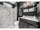 Modern bathroom with a glass shower, black vanity, contemporary fixtures, and luxury marble tile at 19507 Dufour Ct, Cornelius, NC 28031
