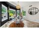 Bright dining room boasts a glass table, clear chairs, designer light fixture, and large windows at 19507 Dufour Ct, Cornelius, NC 28031