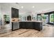 Open concept kitchen featuring dark cabinets, modern appliances, and a breakfast bar at 19507 Dufour Ct, Cornelius, NC 28031