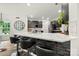 Open concept kitchen with white marble counters, dark gray cabinets, modern appliances and breakfast bar at 19507 Dufour Ct, Cornelius, NC 28031