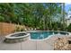 Backyard pool and hot tub surrounded by lush greenery and a wood fence offer a private oasis at 19507 Dufour Ct, Cornelius, NC 28031