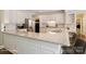 Bright kitchen features white cabinets, stainless steel appliances, and a granite countertop at 20107 N Cove Rd, Cornelius, NC 28031