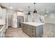 Modern kitchen with stainless steel appliances, gray island with white countertop, and sleek white cabinets at 2232 Tabor Rd # 570, Sherrills Ford, NC 28673