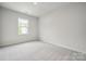 Bright, carpeted bedroom with a large window and neutral-colored walls at 3042 Finchborough Ct # 235, Charlotte, NC 28269
