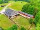 Aerial view of home with long driveway, horse paddock, white fencing, large barn, and fenced backyard at 3091 Old Meeting House Rd, Sharon, SC 29742