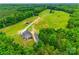 Aerial shot of property featuring a home with a long driveway, large barn, and mature trees at 3091 Old Meeting House Rd, Sharon, SC 29742