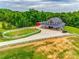 An aerial view of a stunning horse property featuring a barn-style house, green pastures, and white fences at 3091 Old Meeting House Rd, Sharon, SC 29742