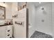 Bathroom featuring a vessel sink, shiplap walls, and white tile shower with rock floor at 3091 Old Meeting House Rd, Sharon, SC 29742