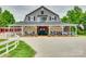 A beautiful farmhouse-style barn with stone accents, a covered porch, and a spacious concrete driveway at 3091 Old Meeting House Rd, Sharon, SC 29742