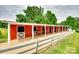 Red horse barn with white trim and a horse standing in one of the stalls at 3091 Old Meeting House Rd, Sharon, SC 29742