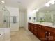 Well-lit bathroom with double vanity, dark wood cabinets, and a glass-enclosed shower at 3224 Dunbar Ln, Fort Mill, SC 29707