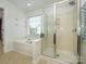 Bright bathroom featuring a large bathtub, glass-enclosed shower, and a window with natural light at 3224 Dunbar Ln, Fort Mill, SC 29707