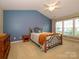 Bright bedroom featuring an ornate metal bed frame, neutral carpet, and a large window at 3224 Dunbar Ln, Fort Mill, SC 29707
