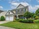 Inviting two-story home with a two-car garage, stone accents, and lush landscaping at 3224 Dunbar Ln, Fort Mill, SC 29707