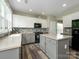 Modern kitchen boasts gray cabinets, black appliances, an island, and natural light from large windows at 3224 Dunbar Ln, Fort Mill, SC 29707