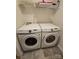 Well-lit laundry area with a side-by-side washer and dryer, complemented by overhead shelving for storage at 324 Gaines Rd # 8, Clover, SC 29710
